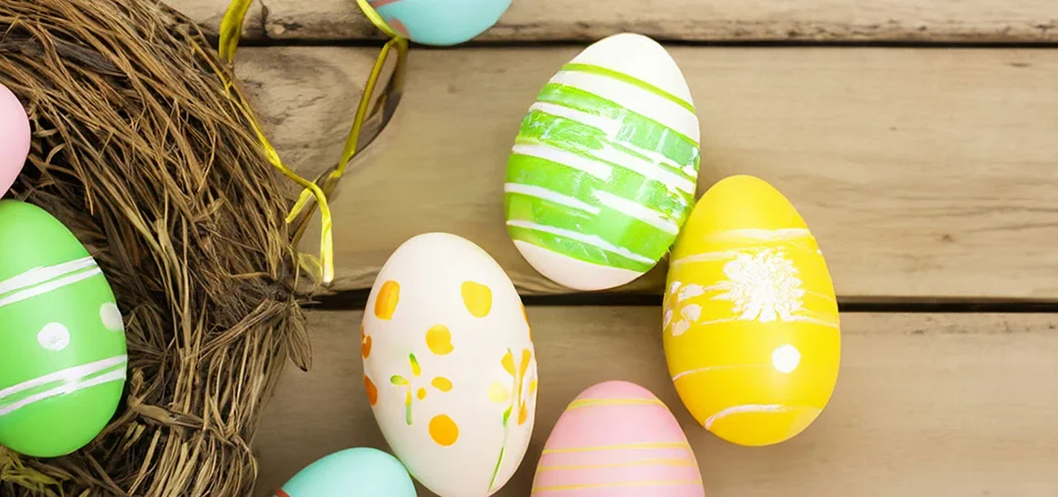 Osternetz bunte Eier auf Holzhintergrund