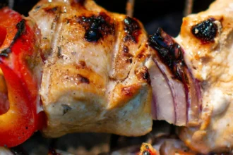 BBQ Spieß mit Fleisch und Gemüse über Feuern auf dem Grill